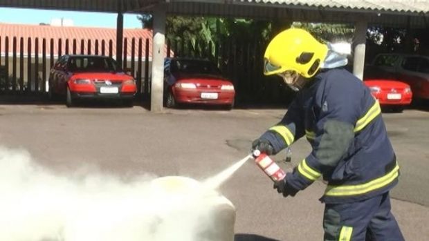 Uma linda bombeira e um extintor de incêndio vão apagar o fogo e