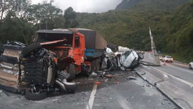 Carro fica destruído após cair de caminhão-cegonha que entalou em