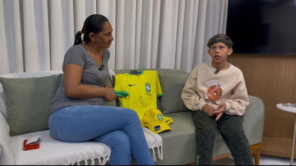 Lorran ao lado da mãe,  Maria, que pede ajuda para despesas de estadia